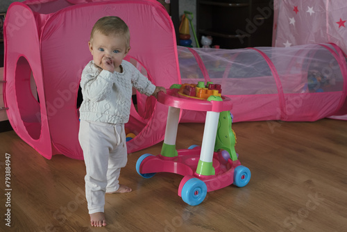 Cute child with walker in playroom