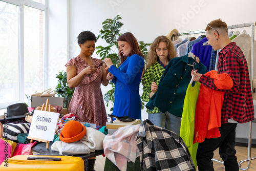 second-hand store, saving money and family budget, young people students at swap party try on clothes, bags, shoes and accessories, change clothes with each other, second hand for things, zero waste photo