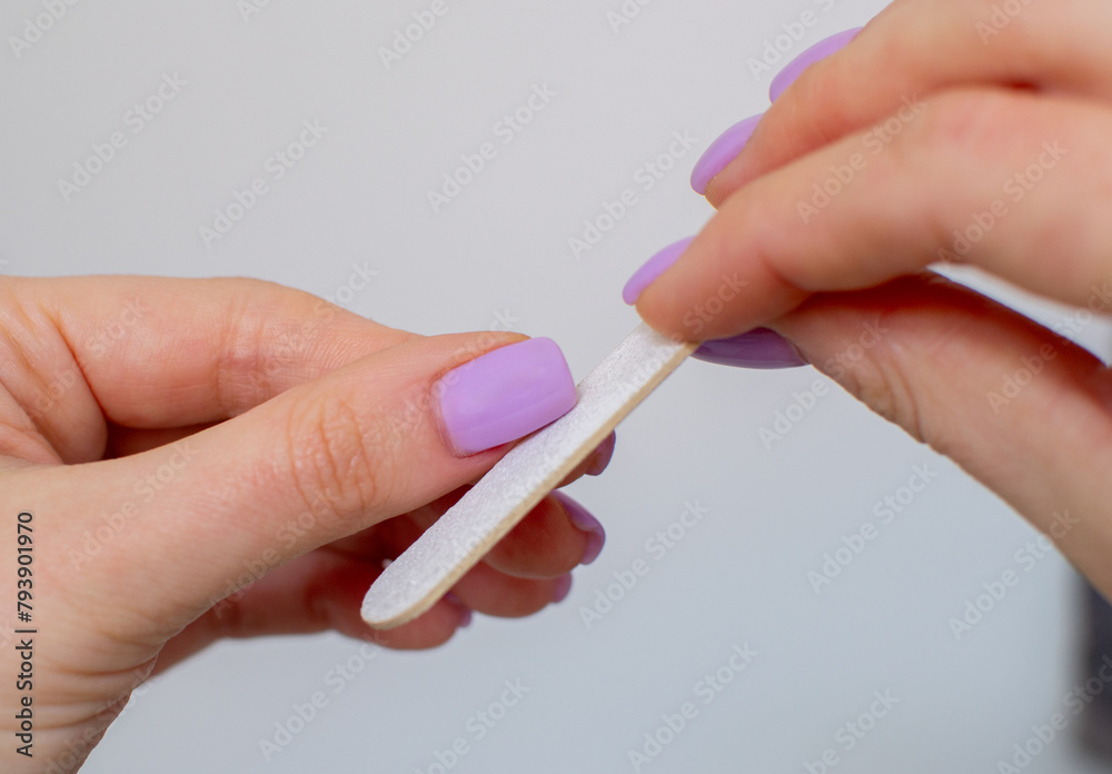 Close up picture of nail care. Manicured woman fingernails holding nail file. Nail polish. Close-up of hand with manicure isolated on white. Nails manicure with file. beauty concept Close up picture of nail care. Manicured woman fingernails holding nail file. Nail polish. Close-up of hand with manicure isolated on white. Nails manicure with file. beauty concept
