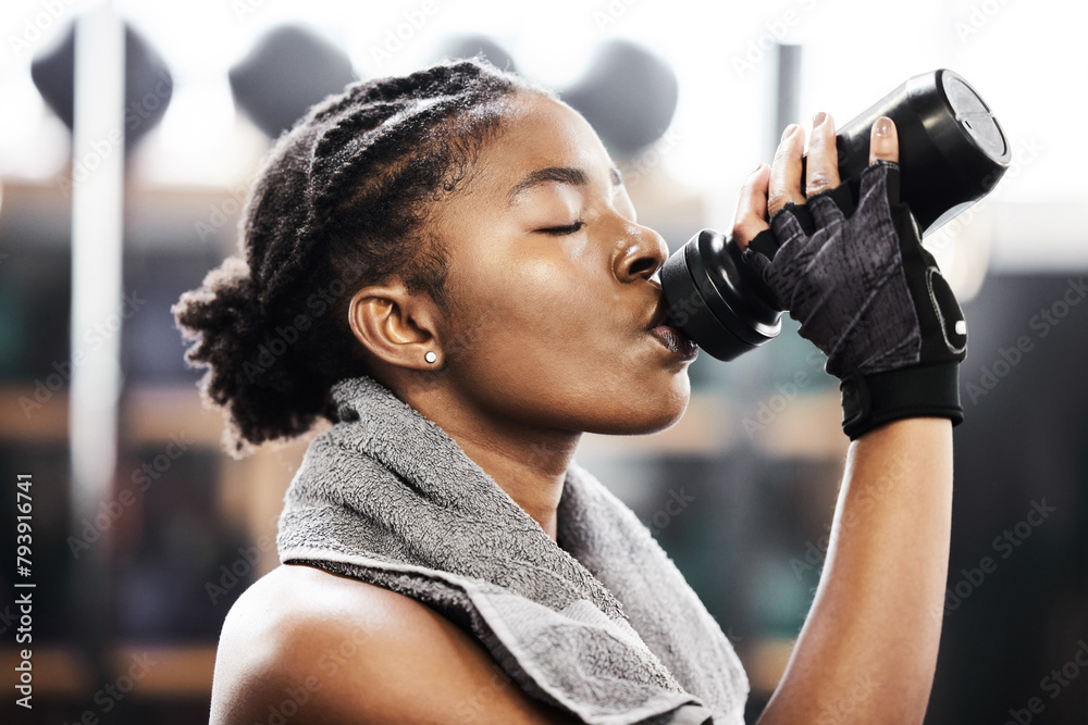 Fototapeta premium Active, black woman and fitness by drinking water in gym for health or energy from training or workout. Sporty, female person and hydration for wellness or nutrition for routine with cardio