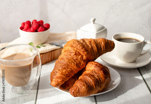 Cup of coffee and croissants and berries. on white wooden. breakfast. Morning.