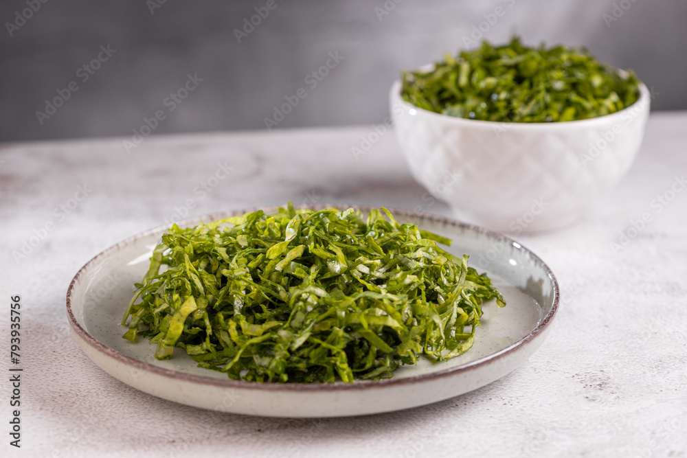 Plate with chopped kale leaves. Green cabbage leaves. Plate with chopped kale leaves. Green cabbage leaves.