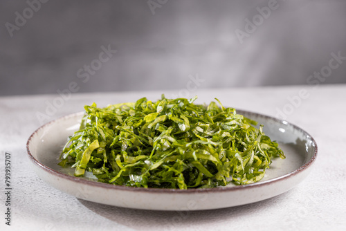 Plate with chopped kale leaves. Green cabbage leaves.