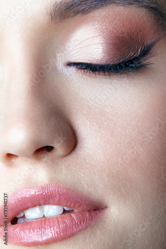 Closeup macro shot of human female face. Woman with closed eyes and lips beauty makeup