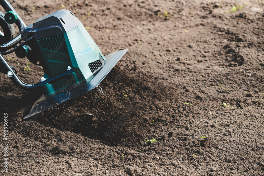 farmer prepares the soil for planting with electric cultivator farmer prepares the soil for planting with electric cultivator