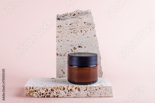 Amber glass jar mockup for moisturizer cream on marble podium on pastel pink background. Cosmetic packaging mockup. Natural homemade cosmetics, skincare routine