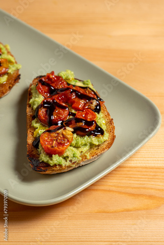 Bilde på lerret A plate of bruschettas topped with vibrant guacamole and cherry tomatoes sits on a restaurant table