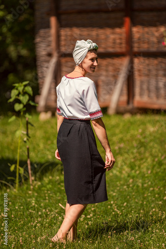 a woman in Ukrainian national costume walks on the lawn