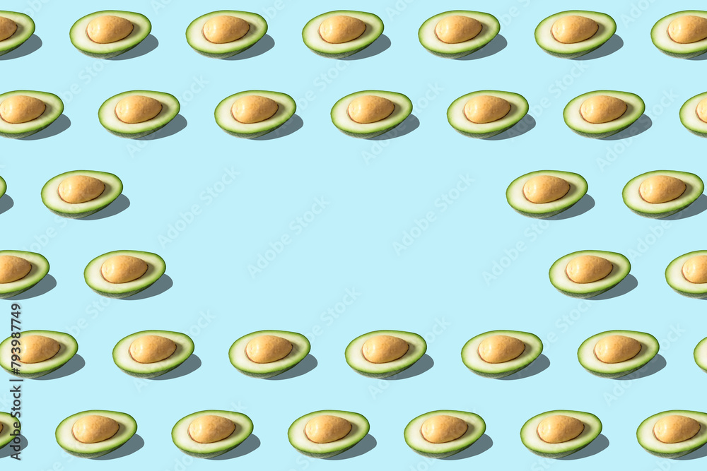 Creative pattern with avocado on blue background. Minimal food concept. Creative pattern with avocado on blue background. Minimal food concept.