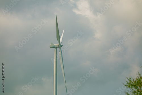 Wind turbine on the brown grass over mountain the blue