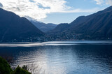 Driving car along shores of Lake Como in Northern Italy, spring sunny days, views of alpine mountains, water and villages