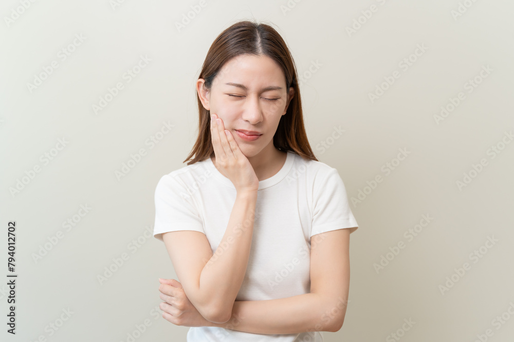 Face expression suffering from sensitive teeth, Asian young woman touching cheek Face expression suffering from sensitive teeth, Asian young woman touching cheek
