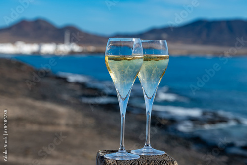 Pouring a glass of champagne on vacation, south of Fuerteventura, Canary islands, blue ocean, mountains photo