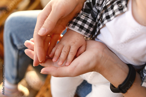 Mommy's hands are holding baby's little hand