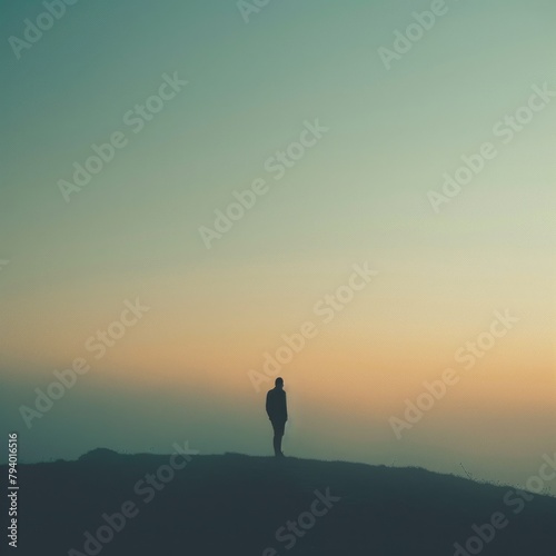 Man standing alone on a hilltop overlooking a foggy landscape
