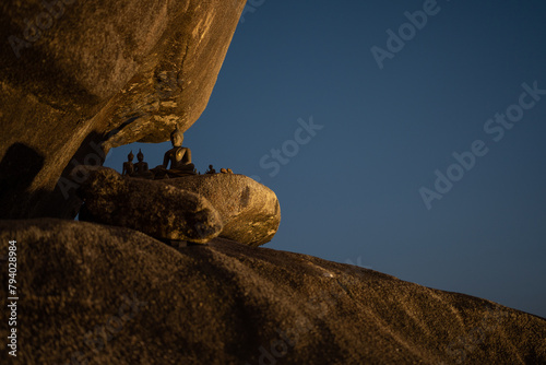 Buddha statue on a rock, and blue sky background. photo