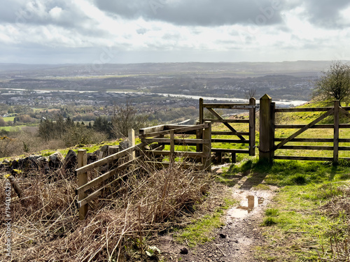 Gate or wooden fence with dirt foot path, track leading to the Scottish highlands, Kilpatrick hills. Sunny but windy typical Scottish weather with sunshine and rain photo