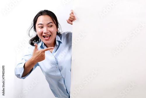 Portrait of young woman happy excited positive smile point finger empty space billboard ad advice choice isolated over white background