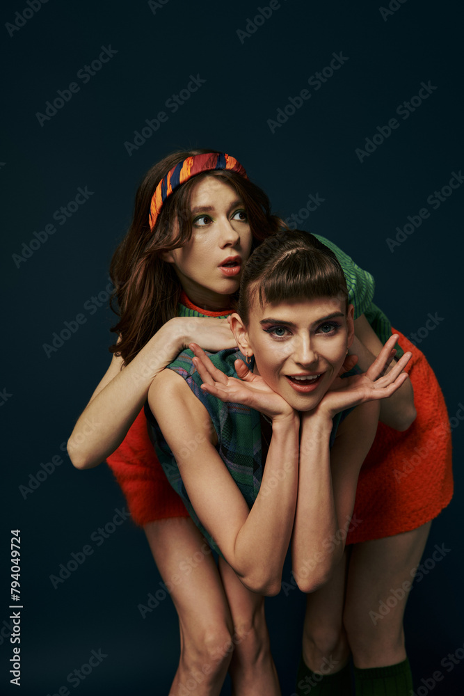 Two women in casual attire strike a pose together. Two women in casual attire strike a pose together.