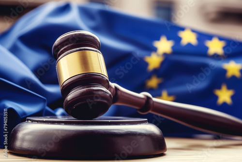 photograph showcasing the intricate details of a judge's wooden gavel, with the EU flag prominently displayed in the background, representing the harmonization of legal principles photo