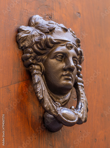 Vintage metal door knocker with a human face.