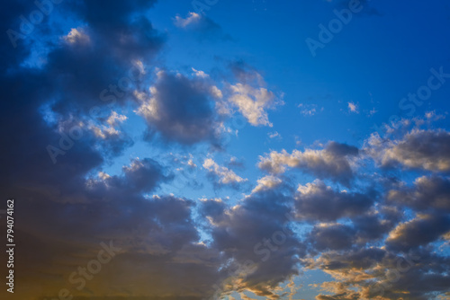 Summer evening sky in the picturesque clouds, lit by the rays of the setting sun. © Anatoliy