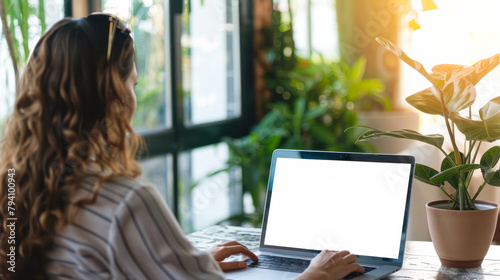 Laptop with blank white screen being used by woman. Female student e-learning distance training course study, work at home office. Young woman watching online education webinar using laptop mock up