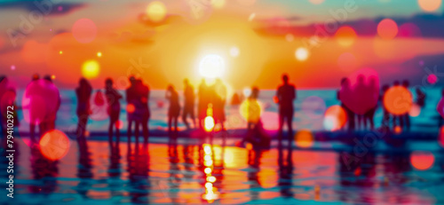 People enjoying a sunset beach party with colorful bokeh