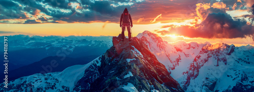 Adventurer on mountain peak at sunset with dramatic sky
