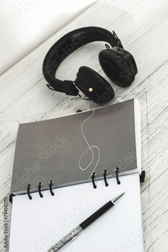 Notepad diary with pen and headphones on the desktop