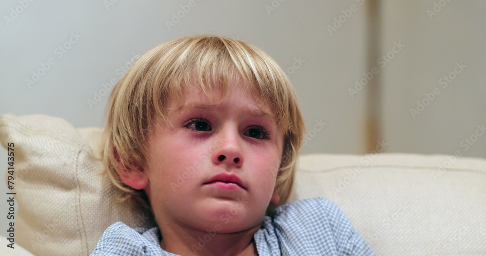 Child seated in sofa watching TV Child seated in sofa watching TV
