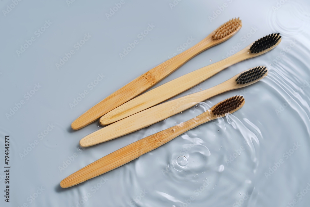 Natural bamboo toothbrushes in water on a blue background. Natural bamboo toothbrushes in water on a blue background.