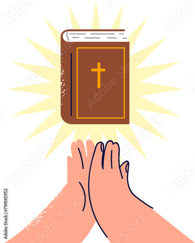 Bible with rays of light near hands of praying man who professes christian religion and reads catholic or orthodox literature. Bible book with crucifix on cover allows believer to become closer to god photo