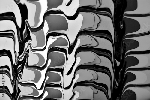 A grayscale image showcasing the intricate patterns of a marbled surface, resembling the pattern found on a tire tread. The symmetrical design is reminiscent of artful automotive tire craftsmanship