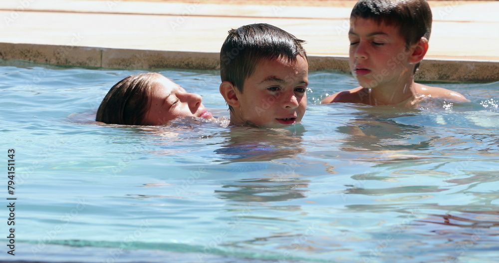 Children at the swimming pool inside water having fun candid and real life Children at the swimming pool inside water having fun candid and real life