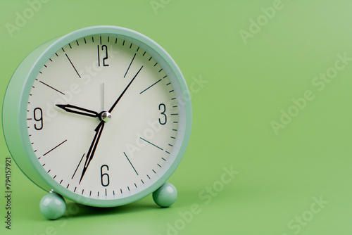 Time, standing still, time hand, photo of a moving clock on a green background, time concept.
