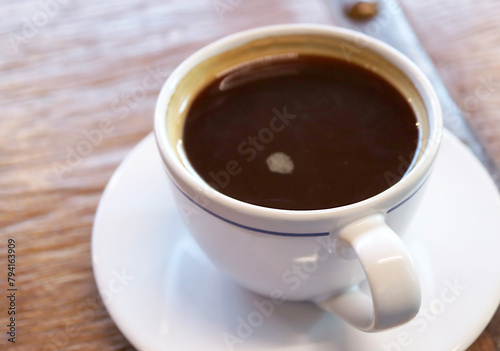 Closeup of a cup of black coffee isolated on wooden table