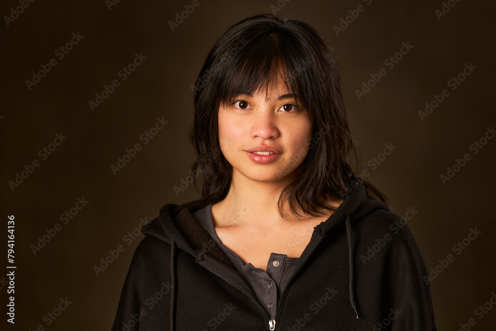 A woman with long hair is wearing a black hoodie A woman with long hair is wearing a black hoodie
