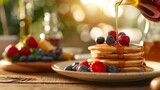 Morning breakfast scene with pancakes, fresh berries, and maple syrup pouring