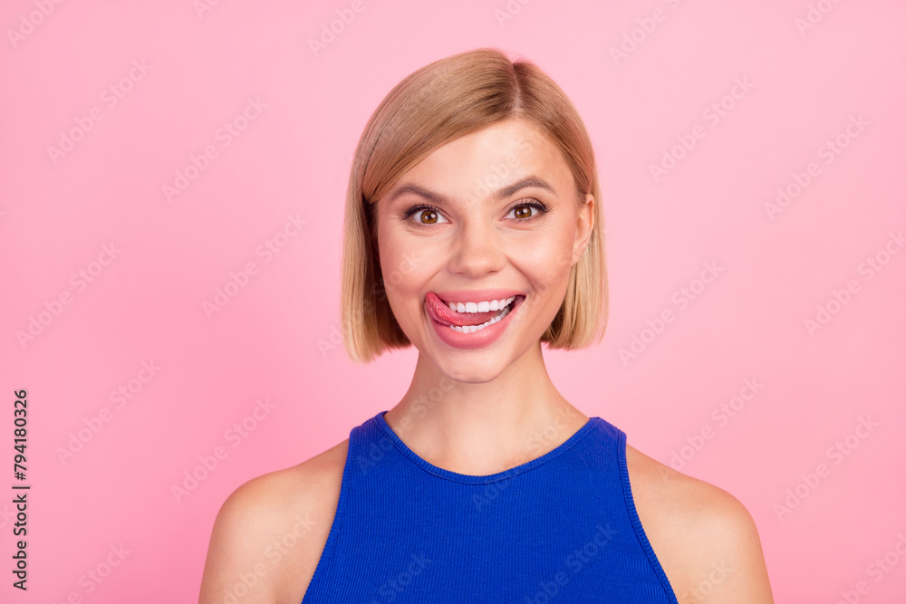 Obraz premium Portrait of nice girl tongue lick teeth empty space wear blue top isolated on pink color background