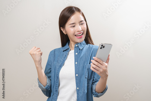 Happy with phone asian young woman, girl holding mobile smart phone, read good news winning feel excited getting offer, great positive surprise, celebrate success on smartphone isolated on background.