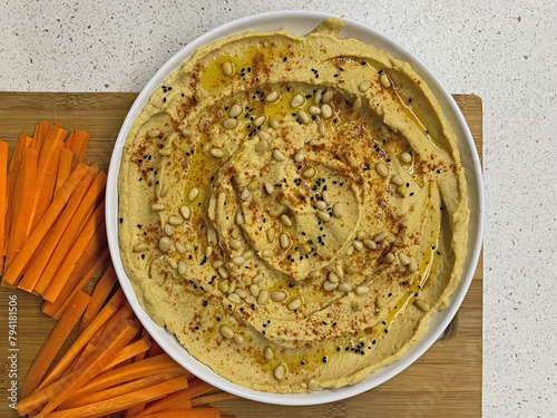 Homemade hummus with a piece of fresh carrot