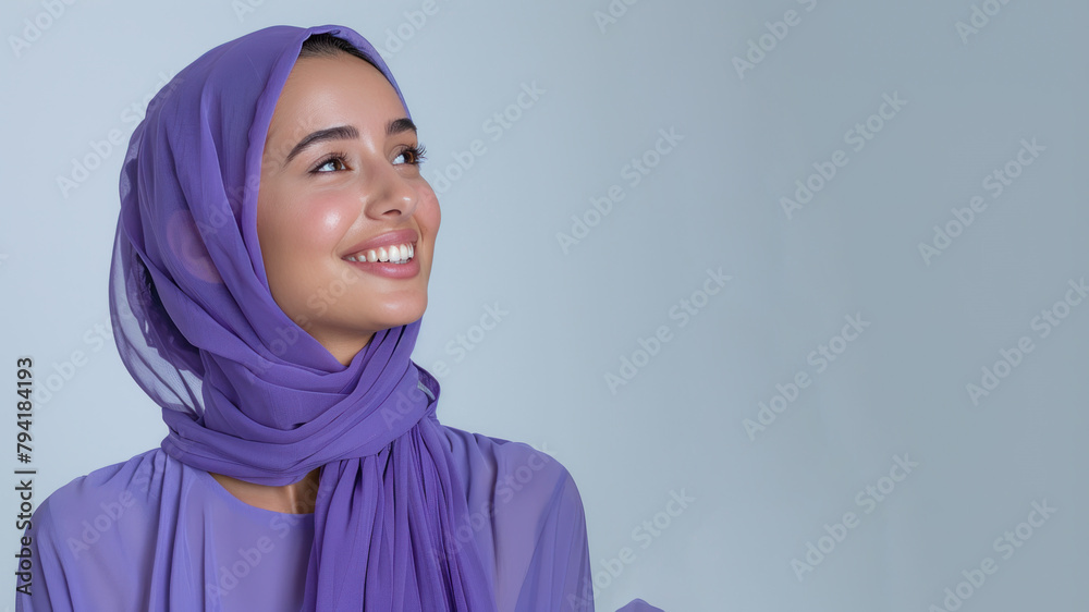 Arab woman wearing purple shirt smile looking up isolated on gray Arab woman wearing purple shirt smile looking up isolated on gray
