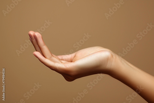 Close up of woman hand with palm facing upwards isolated on brown background. Female hand showing empty hand. Woman holding your beauty product