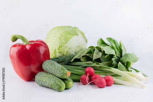 On a white background, cucumbers, radishes, greens, red peppers, iceberg lettuce.