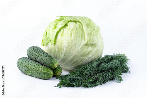 Cucumbers, greens and iceberg lettuce on a white background.