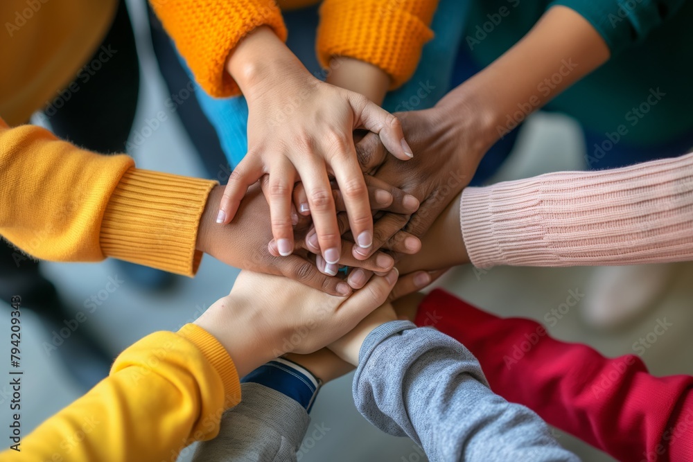 Group of friends with hands stacked one on top of another, friendship, support, togetherness. Multiethnic businesspeople with hands touching on top of each other Group of friends with hands stacked one on top of another, friendship, support, togetherness. Multiethnic businesspeople with hands touching on top of each other