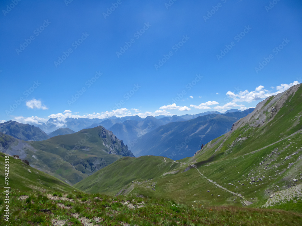 Obraz premium Scenic view from Monte Oserot near rifugio della Gardetta on Italy French border in Maira valley in Cottian Alps, Piedmont, Italy, Europe. Hiking on alpine pasture on sunny summer day in mountains