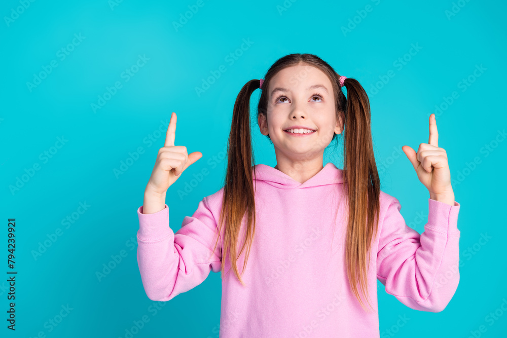 Photo portrait of cute little girl look point up empty space dressed stylish pink clothes isolated on aquamarine color background Photo portrait of cute little girl look point up empty space dressed stylish pink clothes isolated on aquamarine color background