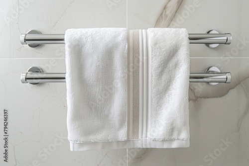 A towel hanging on a towel bar in a bathroom. Suitable for home decor and interior design projects photo
